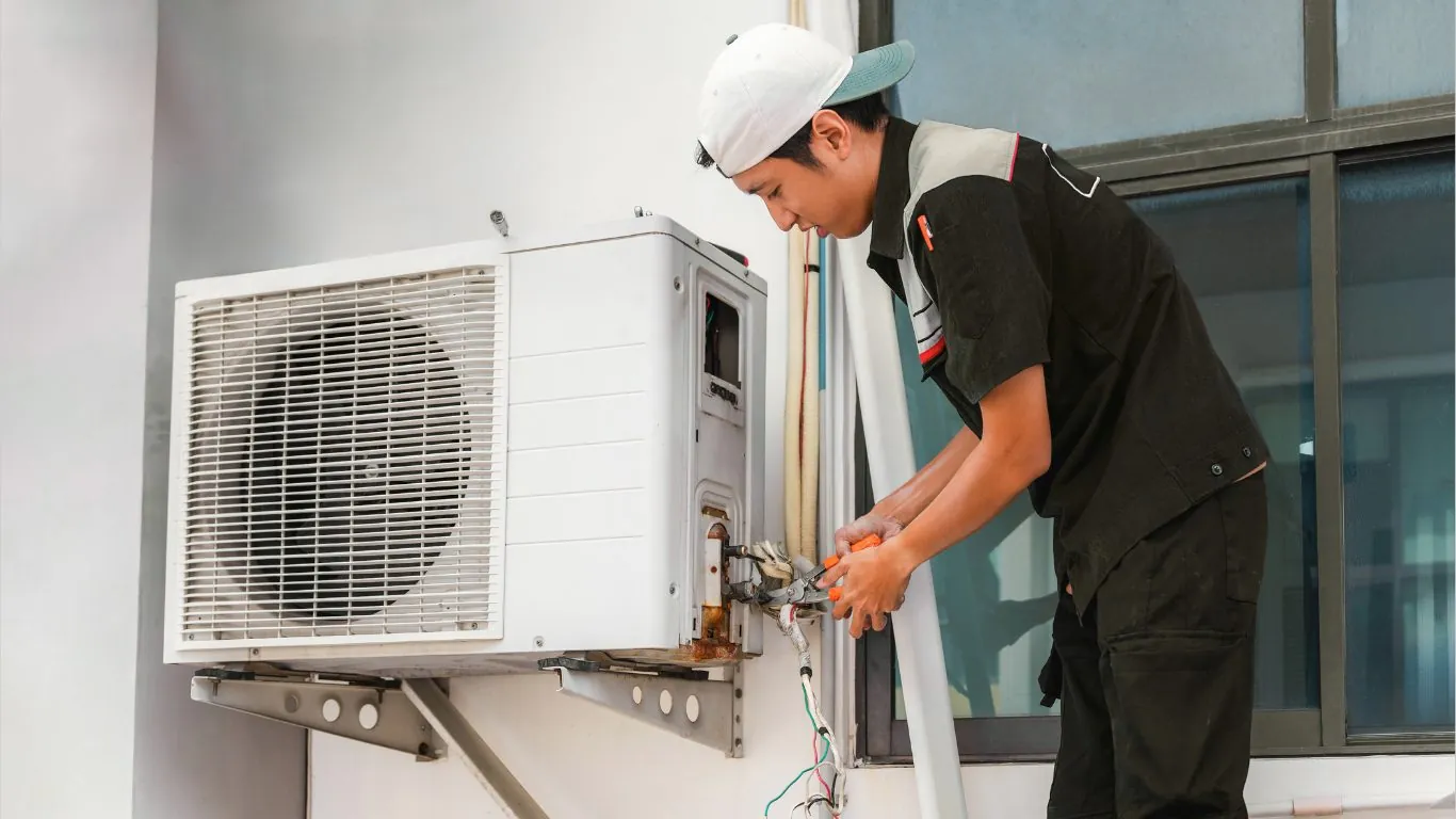 Teknisi memperbaiki unit AC outdoor